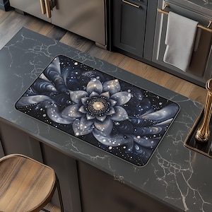 May include: A black and white mouse pad with a large, stylized flower design. The flower has a gold center and is surrounded by swirling patterns.