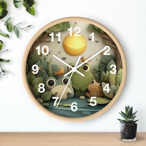 May include: A round wooden wall clock featuring a whimsical frog-themed design. The clock face depicts a serene pond scene with cartoon frogs, birds, and foliage. The clock hands are white, and the numbers are clearly visible.