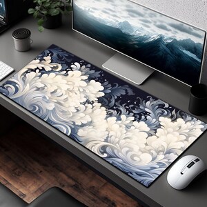 May include: A large, rectangular mouse mat with a dark blue background and a white and blue floral pattern. The pattern resembles stylised waves or clouds.