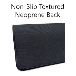 May include: Close-up of a black mousepad with a non-slip textured neoprene back. The mousepad has a dark color and a stitched edge. The text "Non-Slip Textured Neoprene Back" is displayed at the top of the image.