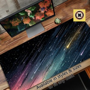 Op de afbeelding: Een rechthoekige bureaumat met een kosmisch ontwerp met een donkerblauwe en zwarte achtergrond met lichtstrepen en sterren. De mat heeft de tekst "Available in styles & sizes to fit any desk."