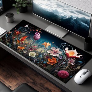 May include: A black and blue floral design mousepad with a dark background. The mousepad features a variety of flowers in shades of pink, red, orange, yellow, and purple. The flowers are surrounded by intricate vines and leaves.