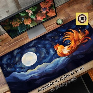 May include: A colorful desk mat featuring a rooster with orange and yellow feathers standing in front of a blue and white starry night sky with a full moon. The text "Available in styles & sizes to fit any desk" is at the bottom of the mat.