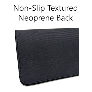 Op de afbeelding: Close-up van de achterkant van een zwarte muismat. De achterkant is gemaakt van getextureerd neopreen en heeft een antislip oppervlak.
