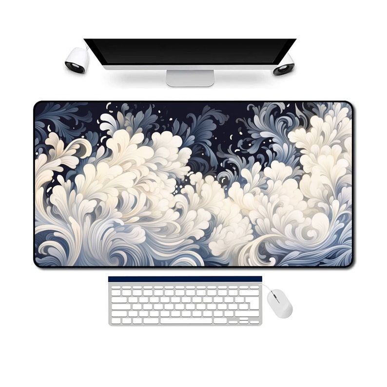 May include: A blue and white abstract floral design mouse mat with a black border. A white keyboard and mouse are on a white surface.