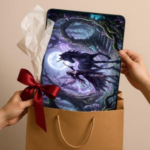 May include: A fantasy art print depicting a black unicorn and a fairy in a moonlit forest. The print is in a brown gift bag, adorned with a red satin bow and white tissue paper.