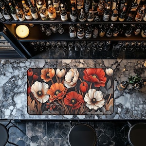 May include: A black and white floral design mouse mat with red, white and orange flowers. The mouse mat is on a marble surface.