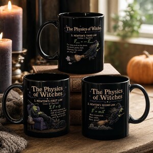 Puede incluir: Tres tazas de cerámica negra con diseños de The Physics of Witches. Cada taza muestra una ley de Newton diferente con una ilustración de una bruja, incluyendo texto que detalla la primera, segunda y tercera ley con fórmulas.