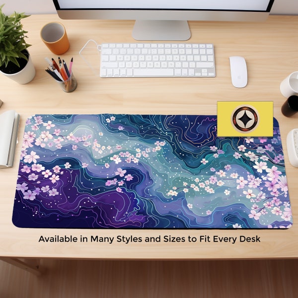 Könnte beinhalten: Eine blaue und violette Schreibtischmatte mit einem wirbelnden Muster und weißen Kirschblüten. Der Text "Available in Many Styles and Sizes to Fit Every Desk" befindet sich am unteren Rand der Matte.