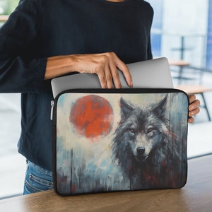 May include: A black laptop sleeve with a watercolor design featuring a wolf with a red moon in the background.
