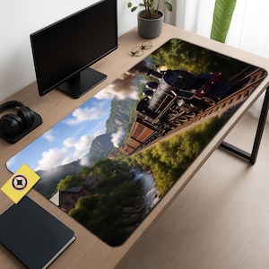 May include: A rectangular desk mat featuring a detailed illustration of a vintage steam train traveling through a mountain landscape. The mat has a black border and a non-slip surface, ideal for a computer setup.