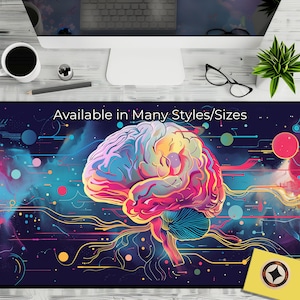 Może przedstawiać: Duża podkładka na biurko z kolorową ilustracją ludzkiego mózgu. Mózg przedstawiony jest w żywych odcieniach różu, żółci, niebieskiego i fioletu, z siecią linii i kropek. U góry widnieje napis "Available in Many Styles/Sizes".