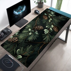 May include: A dark green and black mousepad with a pine branch and pine cone design. The pine cones are gold and brown.