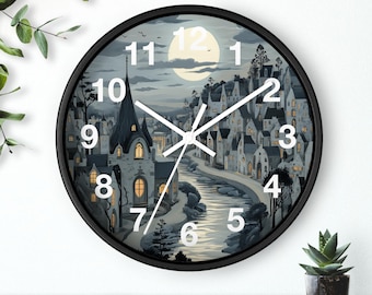 May include: Black wall clock with a white face and black hands. The clock face features a whimsical illustration of a moonlit village with a river running through it. The numbers 1 through 12 are printed in white around the edge of the clock face.