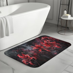 Può includere: Un tappetino da bagno nero e rosso con un design floreale con grandi fiori rossi su uno sfondo scuro.