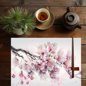 Könnte beinhalten: Ein Aquarellbild eines zarten rosa Kirschblütenzweigs mit weißen Blütenblättern und einem hellrosa Hintergrund. Der Zweig ist mit schwarzer Tinte dargestellt und das Bild hat eine weiche, verträumte Atmosphäre.