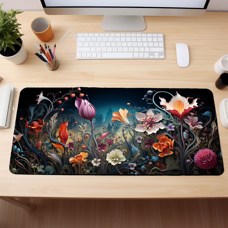 May include: A black mousepad with a colorful floral design. The design features a variety of flowers in shades of pink, red, orange, yellow, and purple. The flowers are surrounded by green leaves and vines.