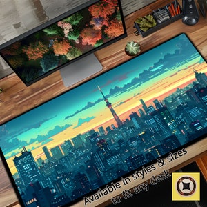 May include: A large, colorful desk mat featuring a pixelated cityscape at sunset with a tall tower in the center. The text "Available in styles & sizes to fit any desk" is at the bottom of the mat.