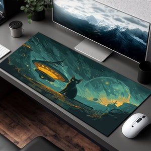 May include: A black cat sits on a green and blue galaxy-themed mousepad with a flying saucer in the background. The mousepad has a starry night sky design with a large planet in the distance.