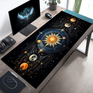 Könnte beinhalten: Eine schwarze und goldene Mauspad im Galaxie-Design mit einer großen Sonne und Planeten in der Mitte. Die Sonne ist leuchtend orange und gelb, und die Planeten sind hellblau und grau. Der Hintergrund ist dunkelblau mit goldenen Sternen.