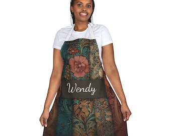 May include: An apron with a floral pattern in shades of brown, teal, and orange. The apron has a dark band across the front with the name "Wendy" in white script. The apron has white straps.