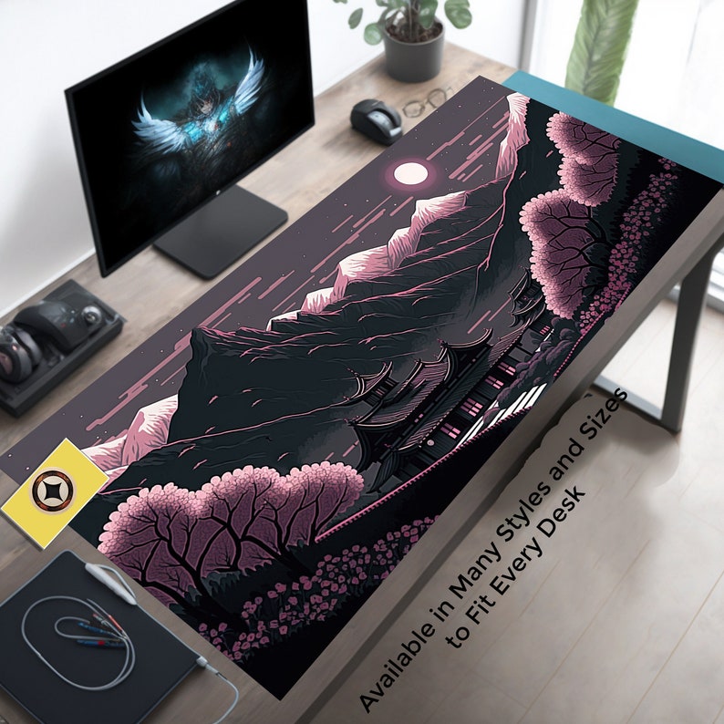 May include: A black and pink illustrated mousepad featuring a Japanese-style temple nestled in a mountain range with cherry blossom trees in the foreground. The text "Available in Many Styles and Sizes to Fit Every Desk" is at the bottom of the mousepad.