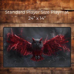 Puede incluir: Alfombrilla de juego rectangular con un fondo oscuro y una imagen impactante de un búho con alas rojas y rayos. La alfombrilla mide 61 cm x 36 cm y presenta el texto "Standard Player Size Playmat".