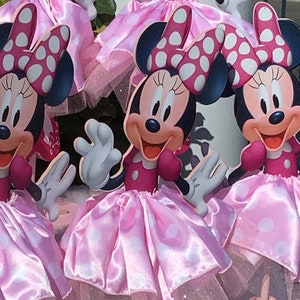 May include: Four pink and white polka dot Minnie Mouse centerpieces with red bows and white tulle skirts.
