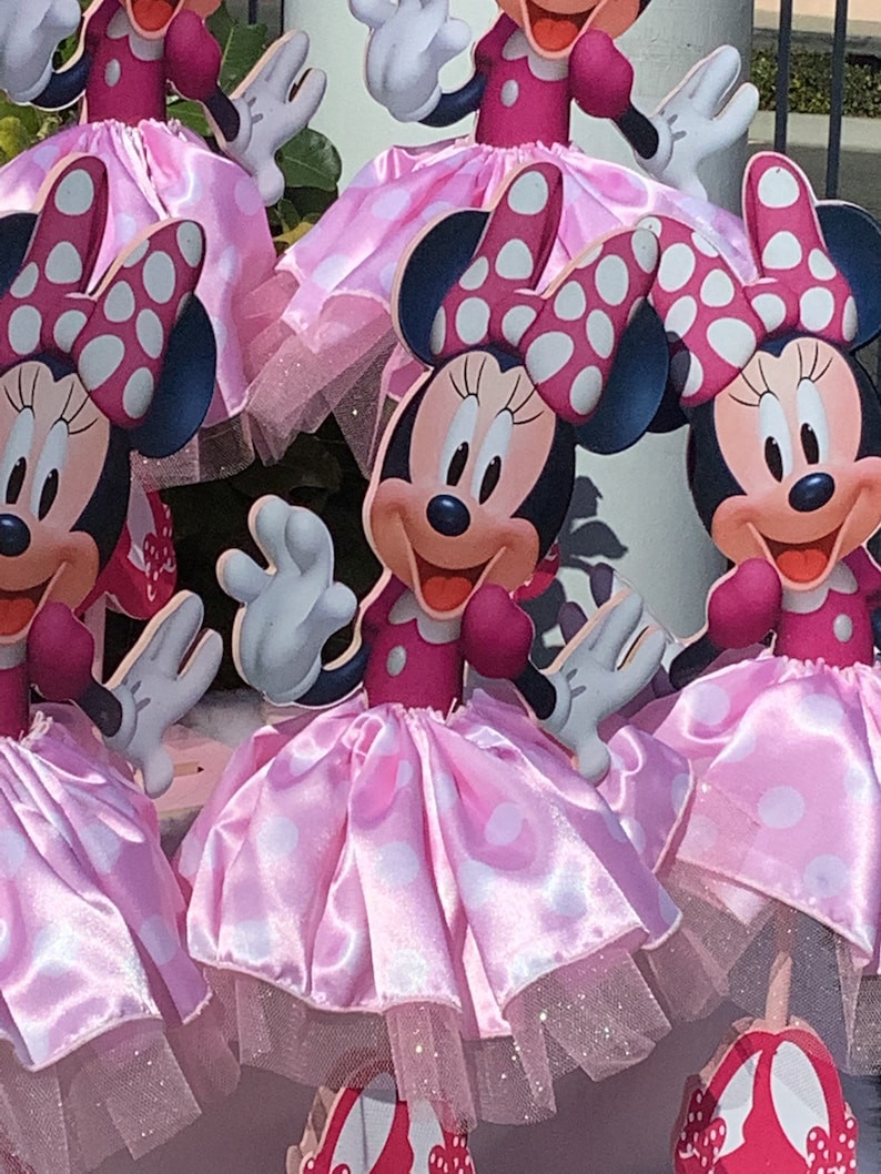 May include: Four pink and white polka dot Minnie Mouse centerpieces with red bows and white tulle skirts.