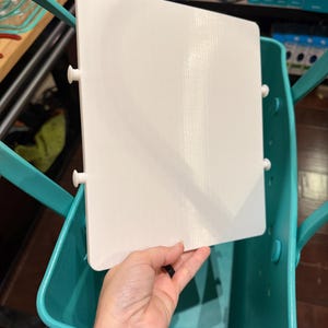 May include: A white rectangular insert with four white pegs is placed inside a teal tote bag. The tote bag has teal handles and is made of a durable material. The insert appears to be a tray or divider.