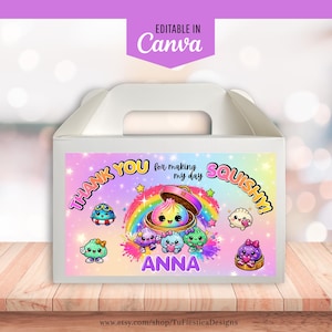 May include: A white cardboard gable box featuring a colorful label with a rainbow, stars, and cartoon dumplings. The text reads "THANK YOU for making my day SQUISHY!" and "ANNA" in purple letters. The design includes various small, cute, colorful dumpling characters.