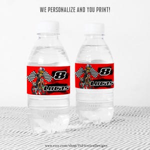 Op de afbeelding: Twee doorzichtige waterflessen met gepersonaliseerde etiketten. De etiketten zijn rood met een motocross racer graphic, het nummer 8 en de naam "Lucas". De tekst "WE PERSONALIZE AND YOU PRINT!" staat bovenaan.