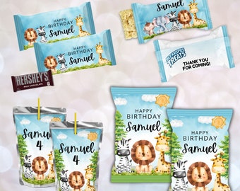Op de afbeelding: Een set bedrukbare feesttasjes met een jungledieren thema met een leeuw, zebra en giraffe. De tasjes zijn blauw en groen met een witte zon en wolken. De tekst op de tasjes luidt "Happy Birthday Samuel".