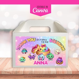 Könnte beinhalten: Eine weiße Pappschachtel mit einem bunten Etikett auf einem regenbogenfarbenen Hintergrund mit Sternenmustern. Das Etikett zeigt Cartoon-Teigtaschen mit Gesichtern, den Text THANK YOU for making my day SQUISHY! und den Namen ANNA in Pink.