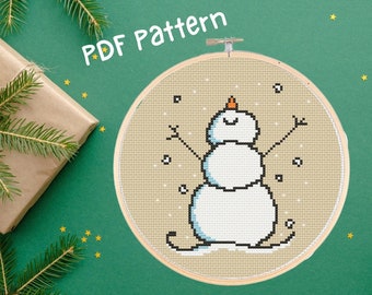 May include: A PDF pattern for cross-stitching a snowman with a carrot nose and a happy face. The snowman is standing on a beige background with white snowflakes.