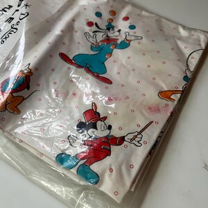 Puede incluir: Juego de s&aacute;banas blancas con los personajes de dibujos animados Goofy, Mickey Mouse y Pluto. La s&aacute;bana tiene un estampado de lunares rojos. Goofy hace malabarismos con bolas de colores y Mickey Mouse lleva un uniforme rojo. El juego est&aacute; en un paquete de pl&aacute;stico.