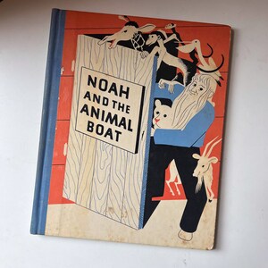 May include: A vintage children's book cover with a red, white, and blue color scheme. The cover features an illustration of Noah and animals entering a wooden ark. The title of the book is "Noah and the Animal Boat."