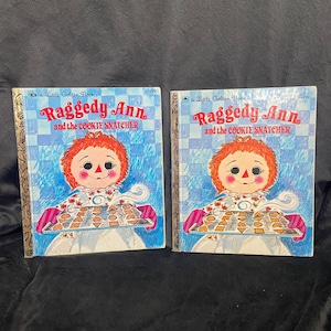 May include: Two vintage Little Golden Books featuring Raggedy Ann and the Cookie Snatcher. The books have a blue and white checkered cover with a picture of Raggedy Ann holding a tray of cookies.