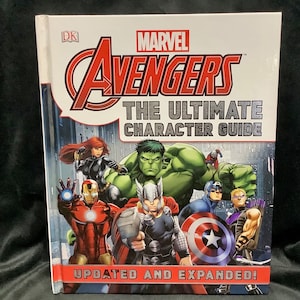 May include: A white book with a red, white, and blue Marvel Avengers logo. The title is "The Ultimate Character Guide" with the words "Updated and Expanded!" at the bottom. The cover features illustrations of Iron Man, Black Widow, Hulk, Thor, Captain America, and Hawkeye.