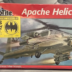May include: A red, white, and blue SnapTite Apache Helicopter model kit with a bonus Batman comic book inside. The box features a large image of the helicopter in flight and the text "Limited Special Edition".