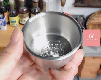 May include: A small, silver, stainless steel bowl with a diameter of approximately 2.5 inches. The bowl has a SUS 304 stamp on the bottom.
