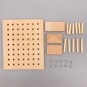 May include: A wooden pegboard with holes, three wooden planks, eight wooden dowels, and five silver hooks. The pegboard is light brown and the planks, dowels, and hooks are natural wood color.