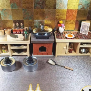 Op de afbeelding: Miniatuurkeuken met houten kasten, een bakstenen fornuis en een roestvrijstalen pot. Inclusief kleine kommen, flesjes, een snijplank en een spatel. Ontworpen voor een poppenhuis of miniatuurtentoonstelling.