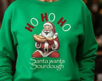 May include: Green Christmas sweater with a cartoon Santa Claus holding two loaves of sourdough bread. The text "Ho Ho Ho" is above Santa and "Santa wants sourdough" is below him.