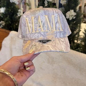 May include: A white ceramic mug with a black handle and the text "But First, Coffee" in a black, bold font. The mug is on a white surface. The mug is approximately 4 inches tall.