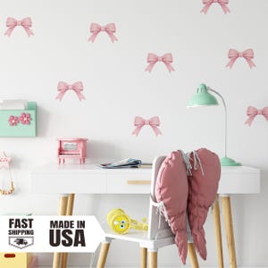 May include: A white desk with a pink piano, a mint green desk lamp, and a white chair with pink cushions. Pink bow decals are on the white wall. The image also includes a sign that says "FAST SHIPPING" and "MADE IN USA".