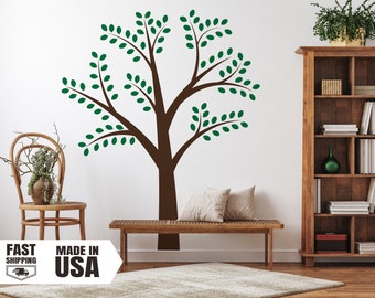 May include: A large wall decal of a tree with a brown trunk and branches, and green leaves. The decal is on a white wall. The image also shows a wooden bench, chair, and bookshelf. The text "MADE IN USA" is visible.