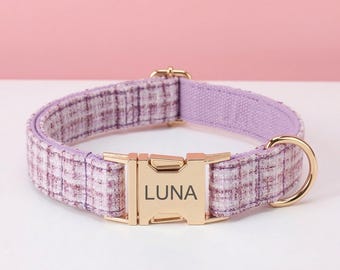 May include: A pet collar featuring a purple and white plaid fabric pattern with a gold-toned metal side-release buckle. The buckle is engraved with the name LUNA in a dark font. The collar includes a gold-toned metal D-ring for attaching a leash.