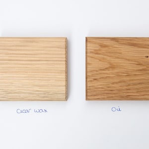 May include: Two wood samples, one treated with clear wax and the other with oil. The wood is a light brown color.