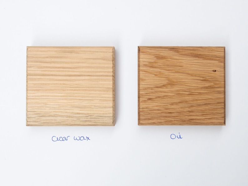 May include: Two wood samples, one treated with clear wax and the other with oil. The wood is a light brown color.